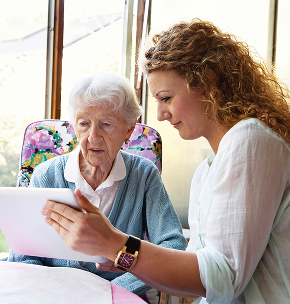 msj social work student helping elderly woman read.