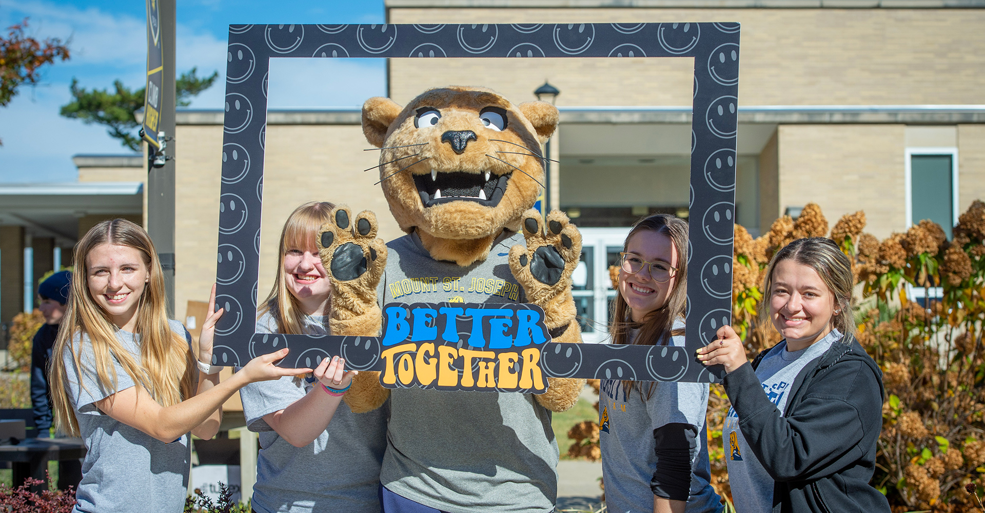 joe lion mascot with freshmen holding photo frame