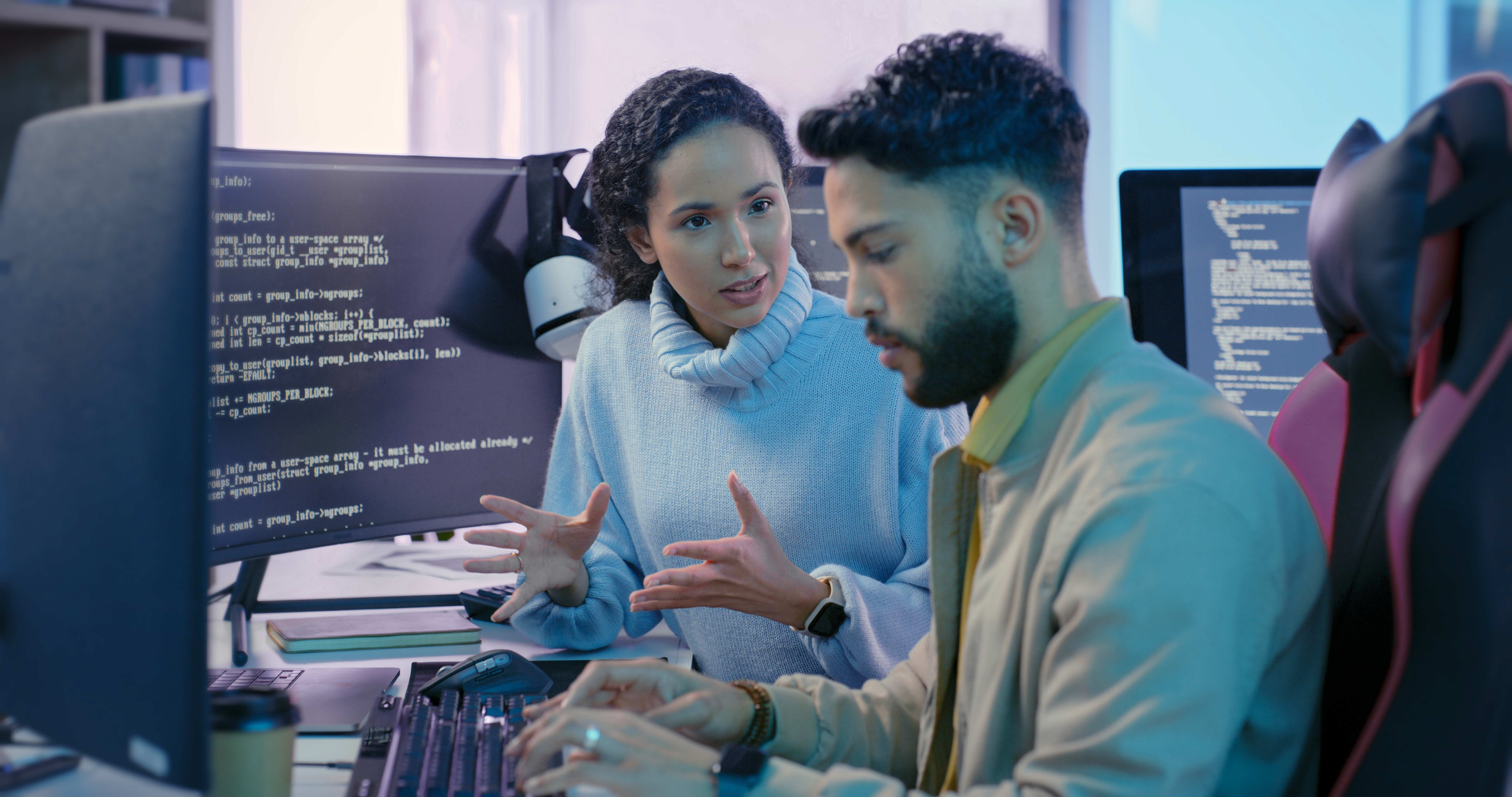 artificial intelligence students talking while on computers with coding