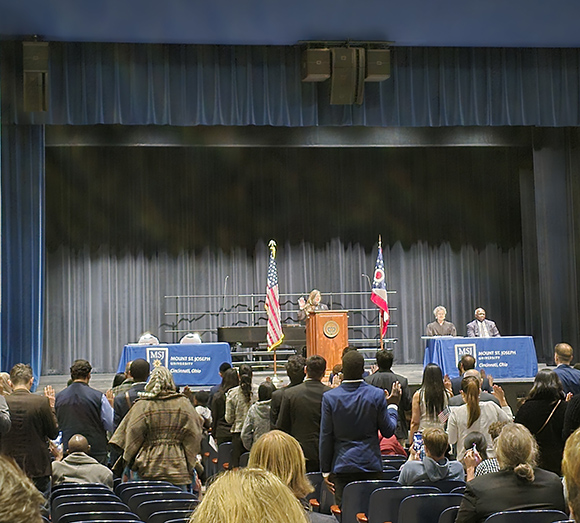 naturalization ceremony citizens taking oath with hands raised