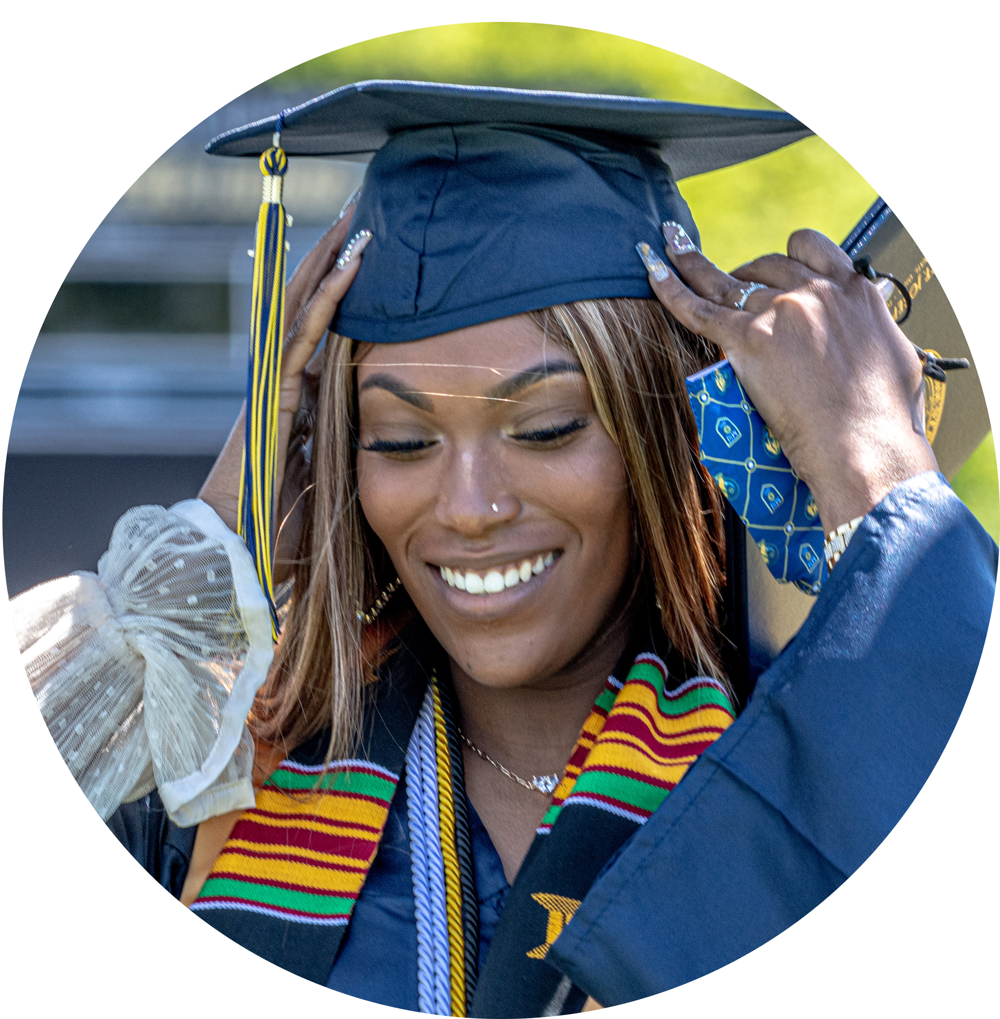 female graduate smiling and holding cap.