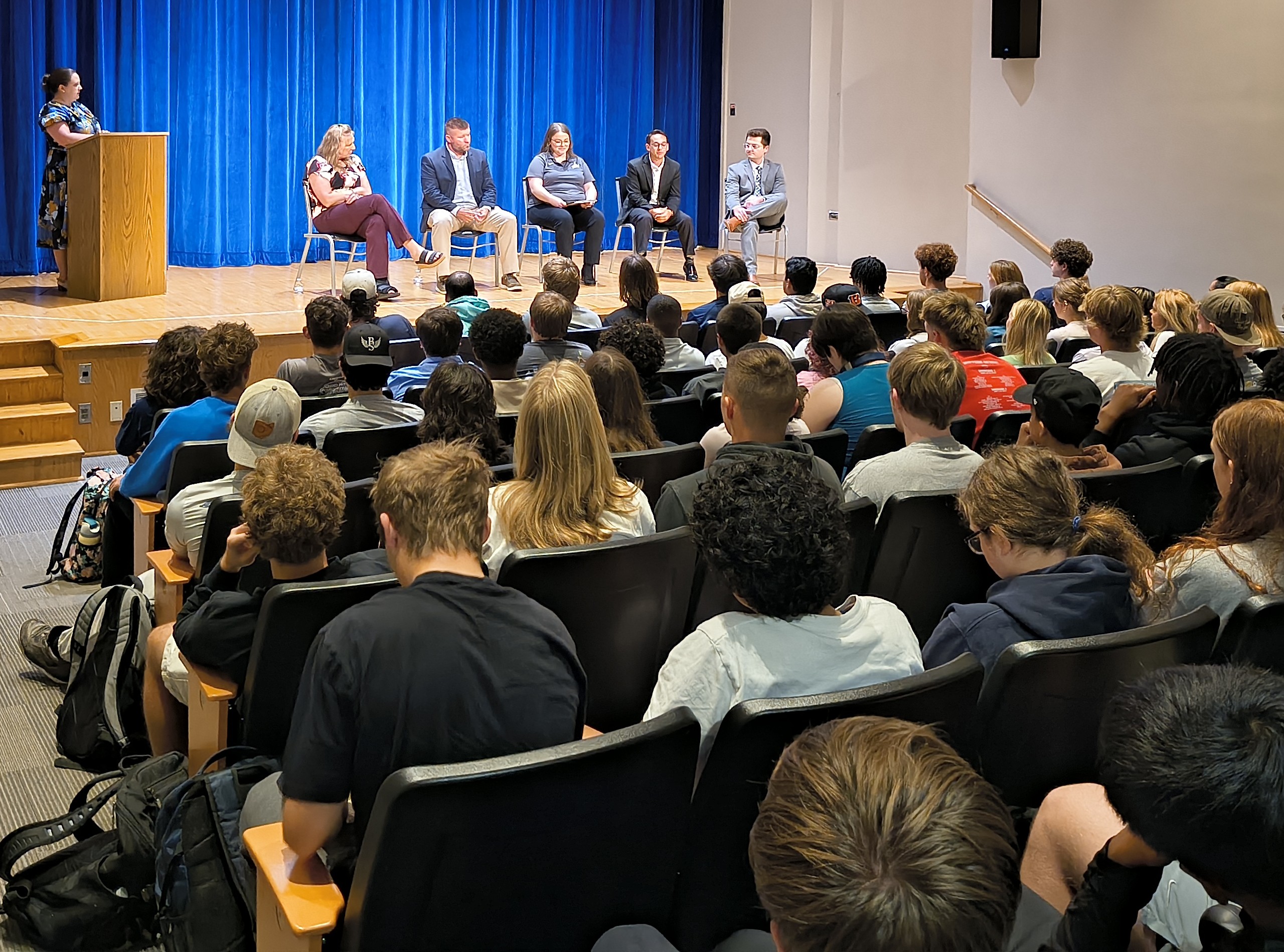people talking on stage in front of audience