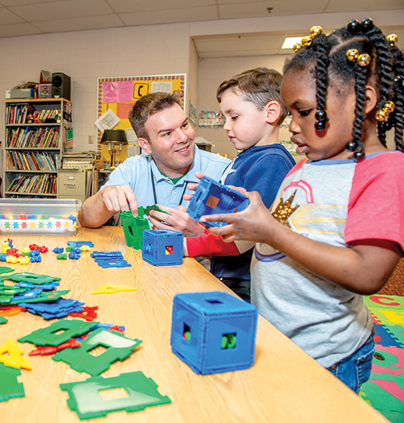 MSJ elementary teacher building blocks with children in classroom
