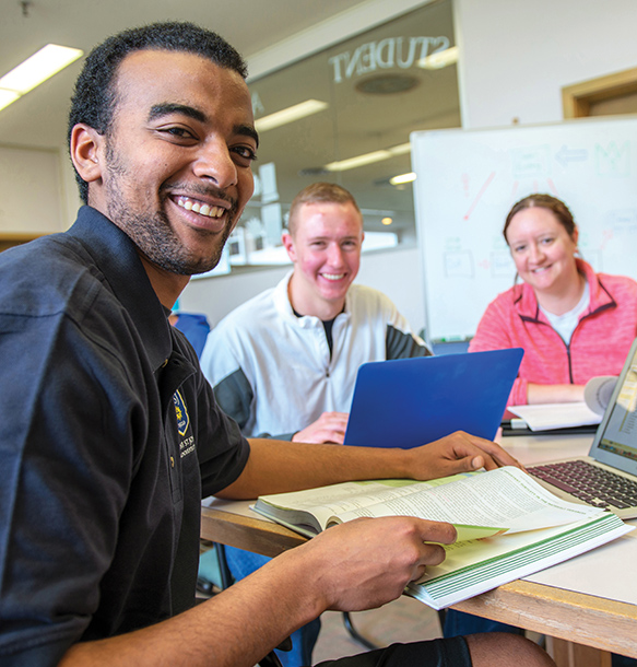 MSJ male and female students sitting on desk
