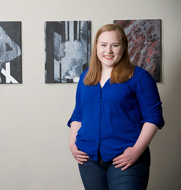 msj art student next to paining in gallery.