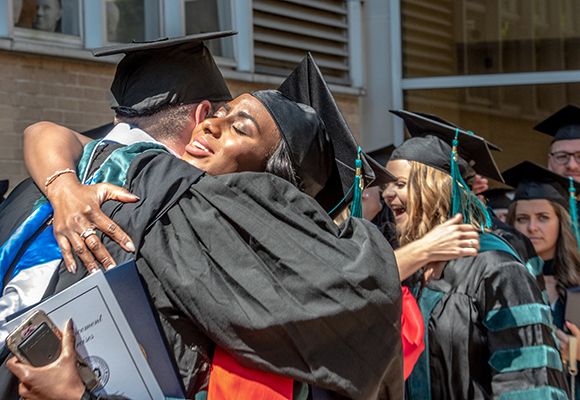 student hugging person at commencement