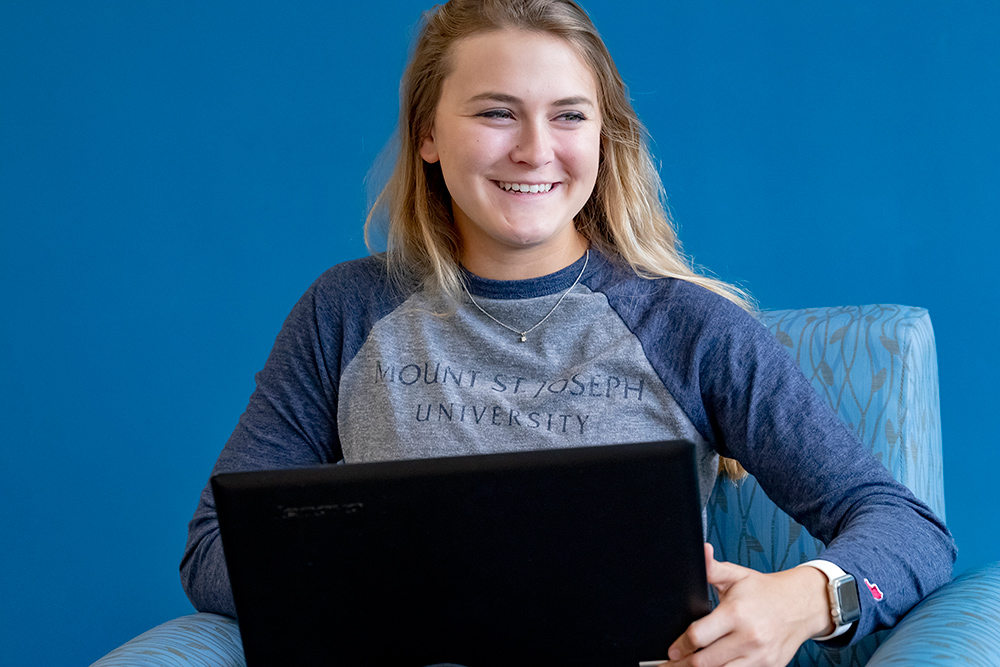 msj female student on laptop smiling.