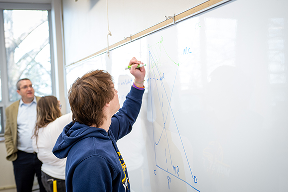 Student drawing a graph on a whiteboard