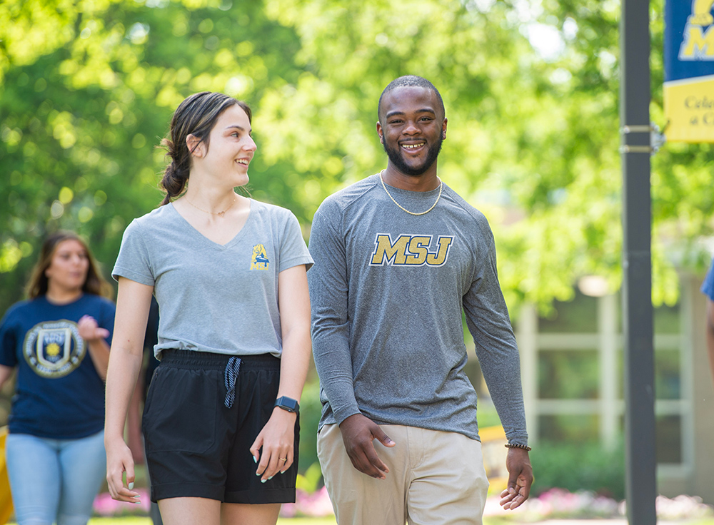 msj students walking in quad smiling with msj shirts