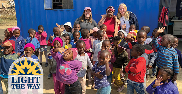 Mount St. Joseph University alumna in group with south african children smiling